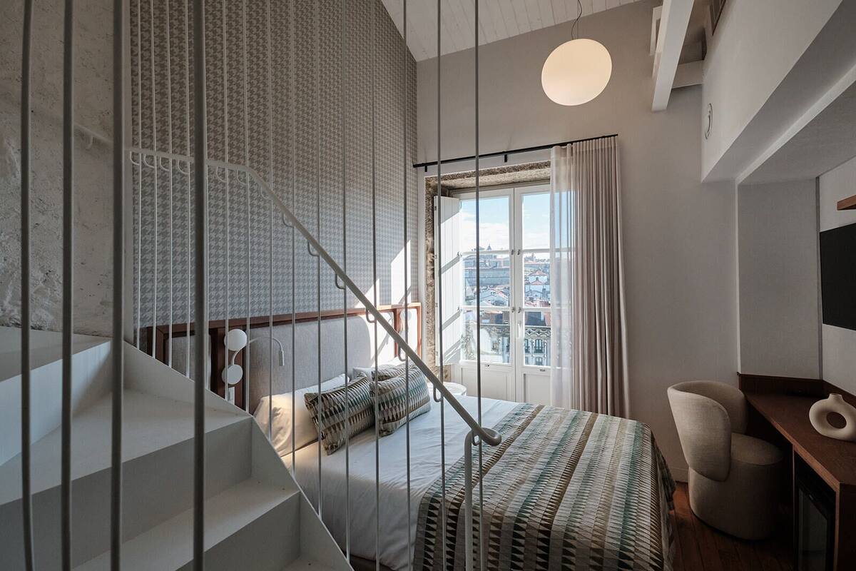Une chambre à coucher moderne avec un lit, un bureau et un escalier.