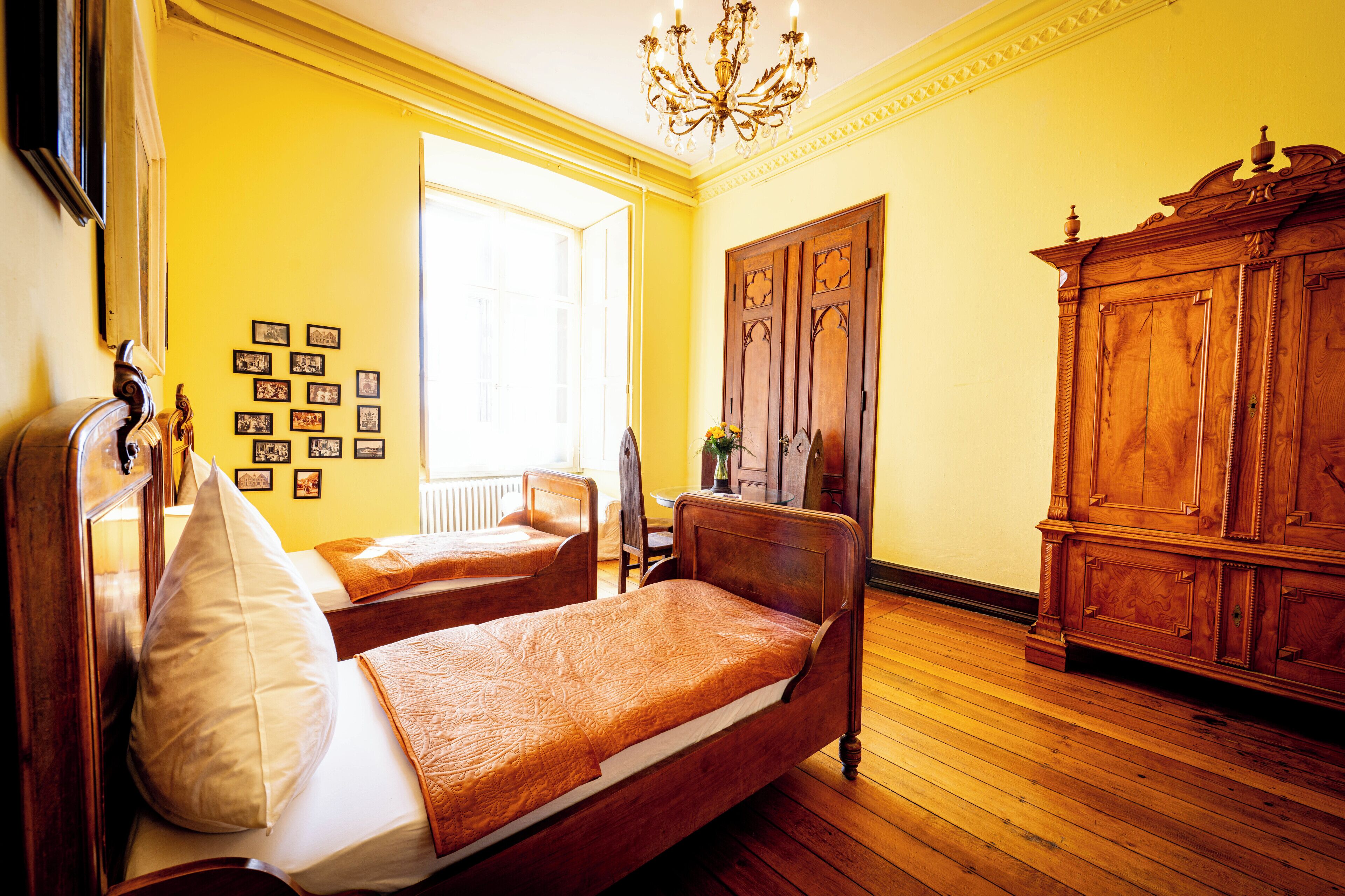 Una habitación con dos camas, muebles de madera y un armario grande.