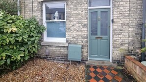 A brick building with a green door and a window with a white frame. - Pet friendly comfortable Victorian terraced home (Cambridge)