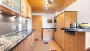 Una cucina moderna con mobili in legno, un piano di lavoro in granito ed elettrodomestici in acciaio inossidabile.