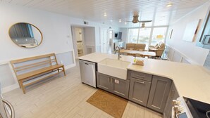 A modern kitchen with a central island, a built-in dishwasher, and a large window providing natural light. - Gorgeous Dolphin Point 604C (Destin)