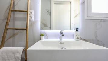 Een douche, handdoeken, zeep, toiletpapier