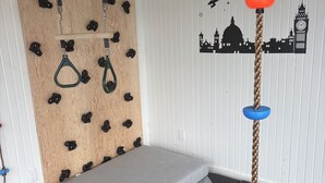 A climbing wall with various holds and a rope ladder. - Luxury cottage (Port Carling)