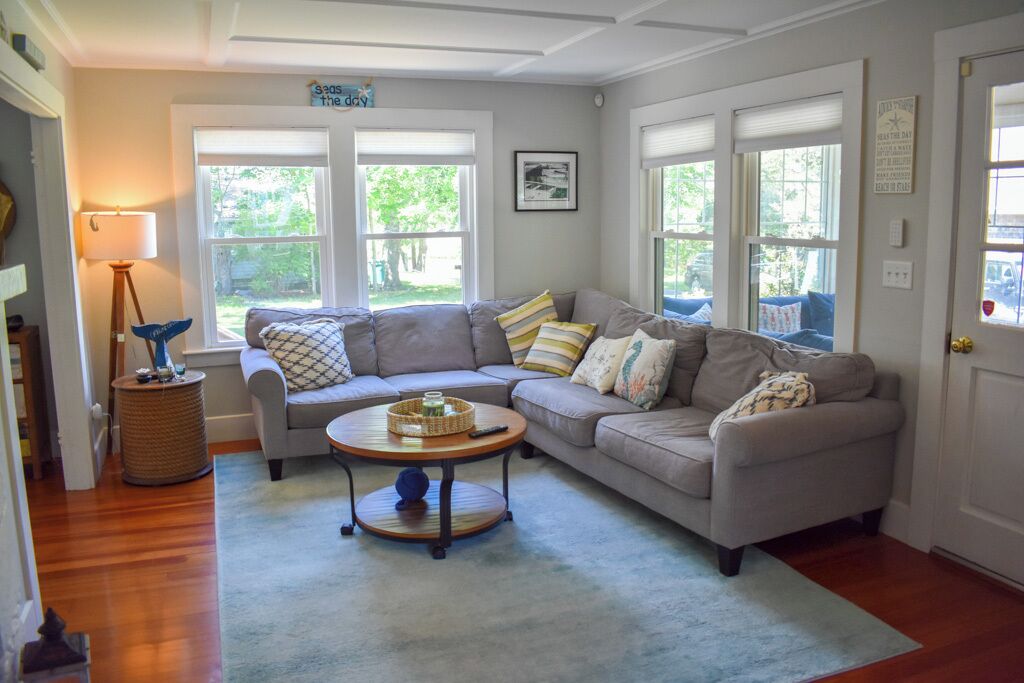 A cozy living room with a grey sofa, a round coffee table, and a lamp.