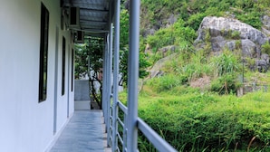 A corridor with a view of a rocky hillside and greenery. - Heartfelt Hideaway (Nam Hoa Lu)