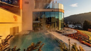 Un edifici modern amb façana de vidre i zona de piscina.