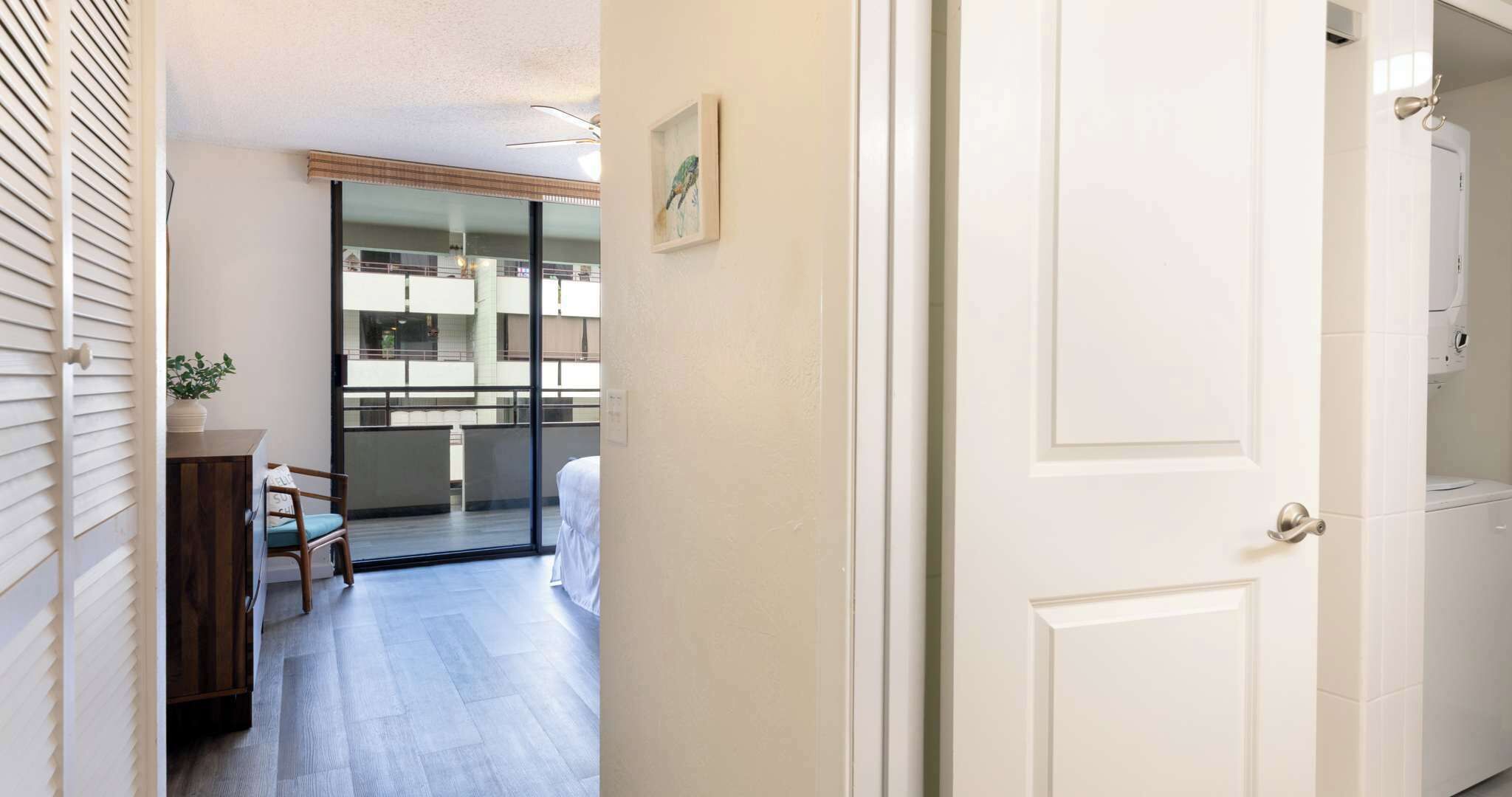 Ein Hotelzimmer mit Balkon, einem Bett, einem Schreibtisch und einem Stuhl.