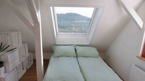 A small, single-bed room with a sloped ceiling and a skylight. - Apartment 'Loft Straussi' with Shared Garden and Wi-Fi (Tuttlingen)