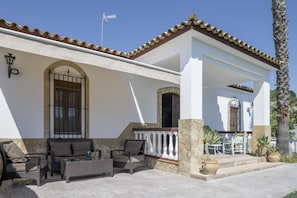 A building with a white exterior, stone accents, and a tiled roof.