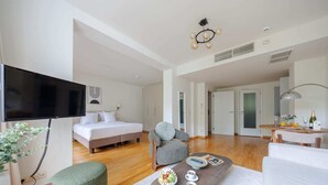 A modern hotel room with a bed, seating area, dining table, and a TV. - Sunny European Studio Mas A-41 (Brussels)