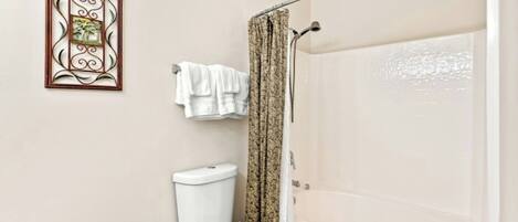 A bathroom with a toilet, a shower, and a bathtub.
