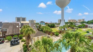 A residential area with a large white water tower, a swimming pool, and various houses. - Kings Grant 203- 2BR Ocean Drive- Pool, Hot Tub (North Myrtle Beach)