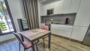 A modern kitchen with a dining area, a microwave, and a refrigerator. - Apartment by Playa de Las Canteras Beach (Las Palmas de Gran Canaria)