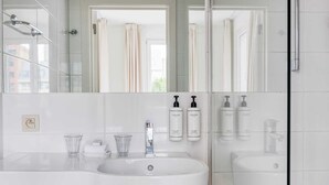A modern bathroom with two sinks, a large mirror, and a shower. - Suite Mas B-42 Studio - Split Level (Brussels)