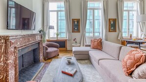 A living room with a fireplace, a sofa, a coffee table, and a television.