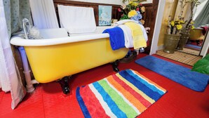Ein Badezimmer mit einer gelben Badewanne, einem Streifen Teppich und einem Blumenstrauß.