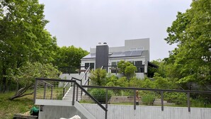 A modern house with a pool, a wooden deck, and a dog. - 3-bedroom house in awesome East Hampton with AC, WiFi, backs up to county park (East Hampton)