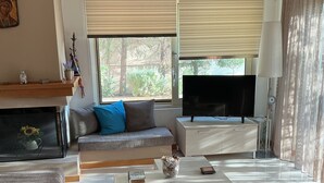Un salon moderne avec un canapé, une table basse et un téléviseur.