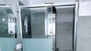 A modern bathroom with a white sink, a glass shower enclosure, and a mirror. - Elegant  peaceful flat with A/C  and all modern appliance in San Frediano (Florence)