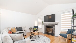 A modern living room with a fireplace, a flat-screen TV, and a comfortable seating area. - Ellerslie - Sleeps 6 - AC - Garage (Edmonton)
