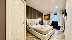 Un dormitorio moderno con una cama grande, una mesita de noche, un aparador y una ventana con cortinas.