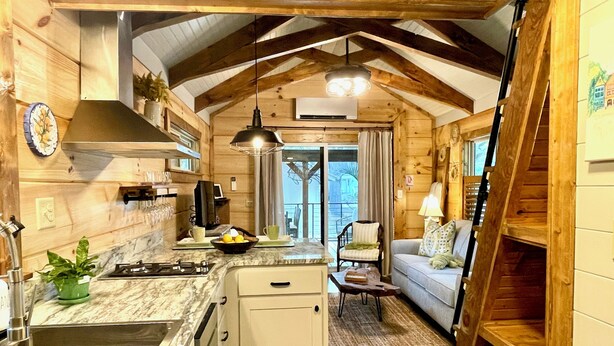 L’intérieur d’un chalet accueillant, comprenant une cuisine, un coin repas et un escalier.