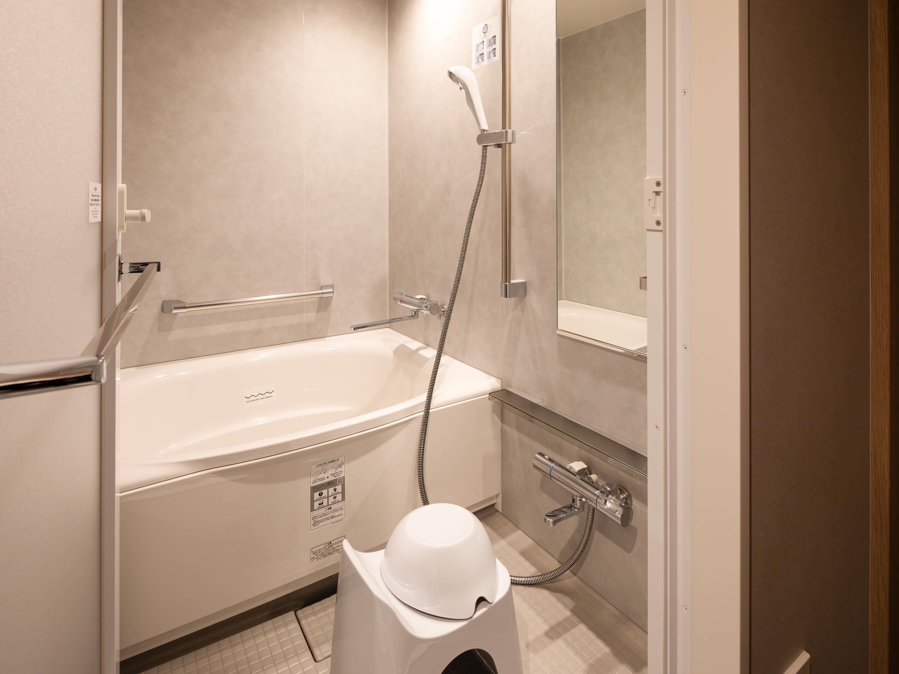 A bathroom with a bathtub, a shower, a toilet, and a hand dryer.