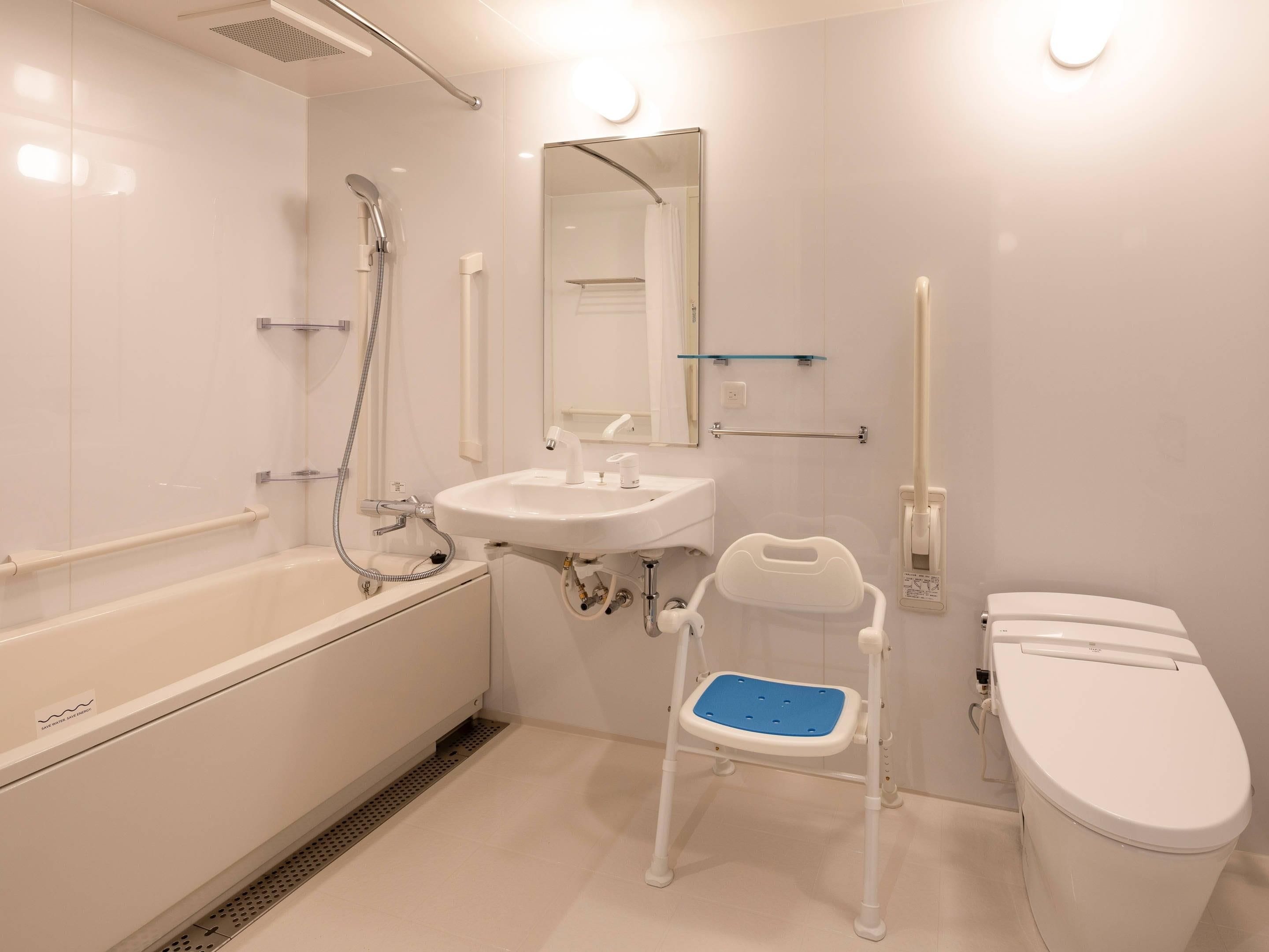 A modern bathroom with a bathtub, sink, mirror, and toilet.