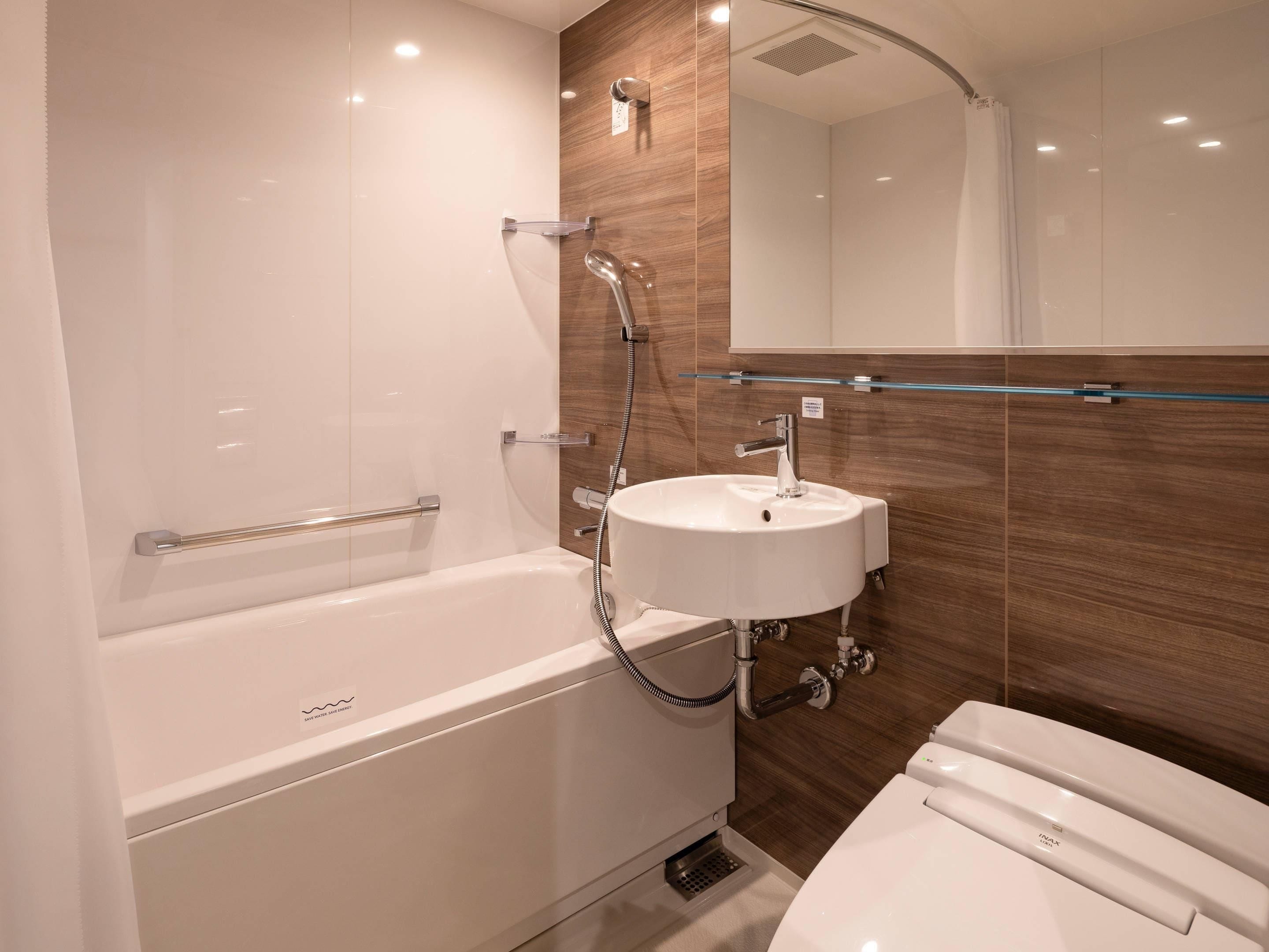 A modern bathroom with a bathtub, a sink, and a toilet.