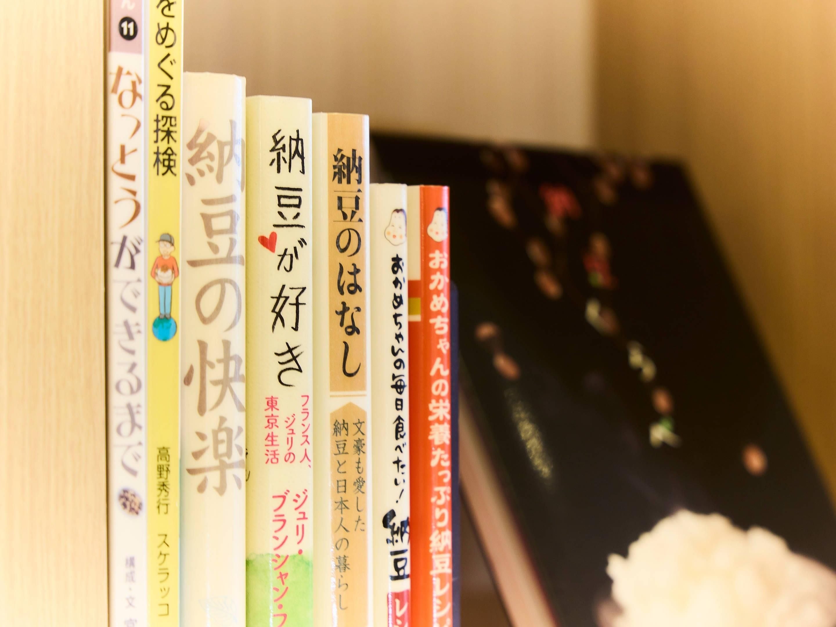 Une rangée de livres écrits en japonais, dont certains comportent des illustrations, sur une étagère.