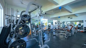 A gym with various weightlifting equipment, mirrors, and motivational wall text.