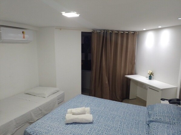 A small, clean room with a single bed, a desk, and a chair. - Nomar V (Joao Pessoa)