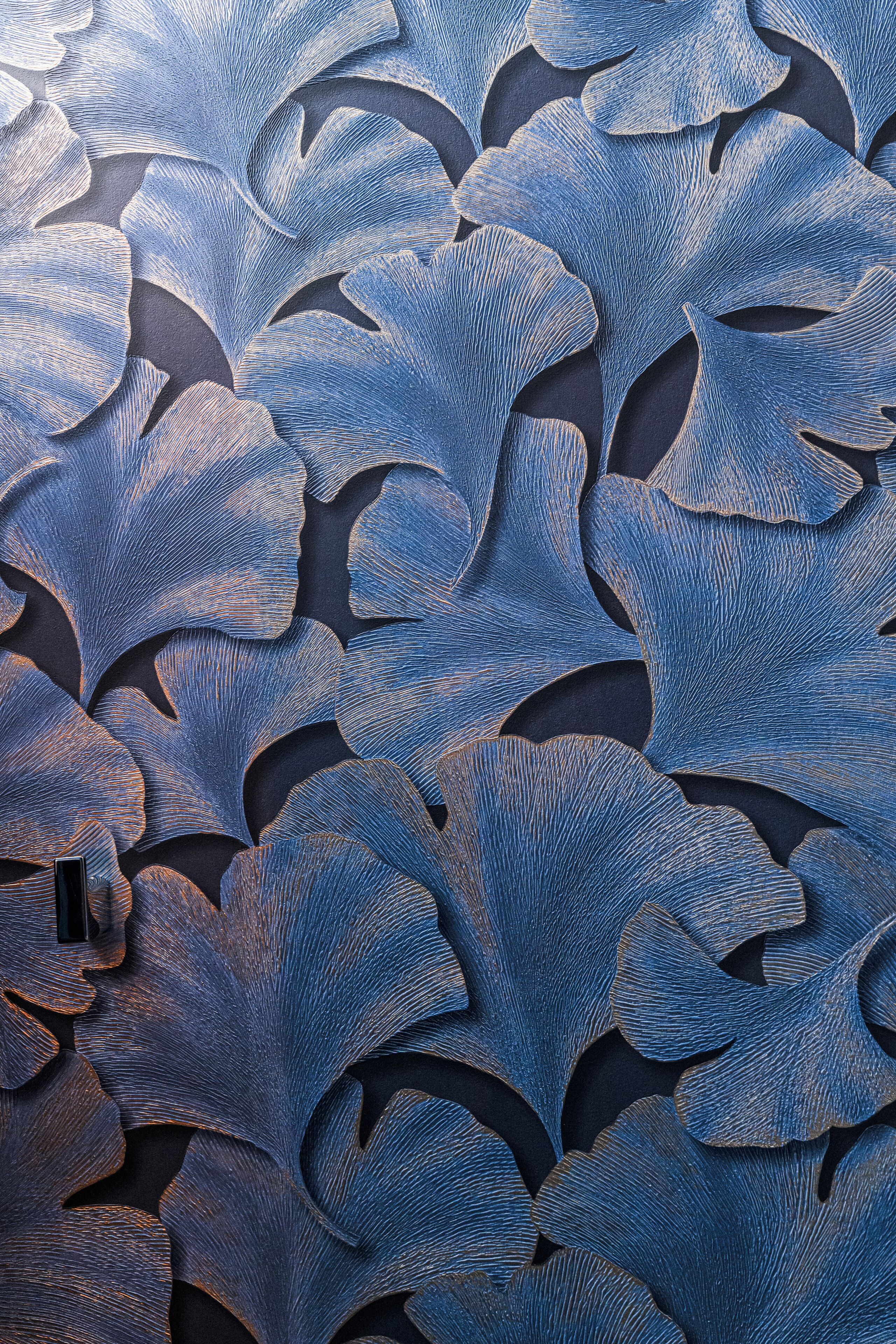 A close-up of a textured wall with a leaf-like pattern.