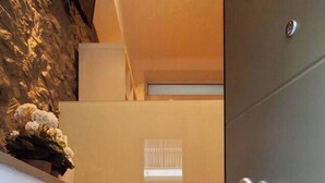 A staircase with a marble finish leading to a room with a large grey door.