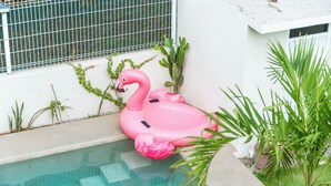Ein Swimmingpool mit einem schwimmenden rosa Flamingo.