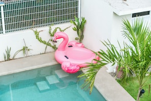Una piscina con un flotador de flamenco rosa.