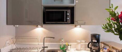 Fridge, microwave, coffee/tea maker, cookware/dishes/utensils