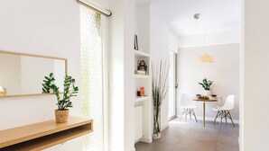 A modern living room with a wooden shelf, a mirror, and a potted plant. - #FH10 New studio in Faliro (Paleo Faliro)