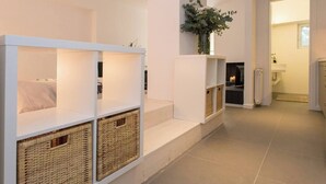 Una habitación de hotel moderna con estanterías integradas, una chimenea y vistas al baño.