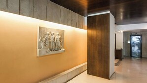A hallway with a marble relief sculpture, wooden paneling, and a modern elevator. - #FH13 Garden level studio in Faliro (Paleo Faliro)