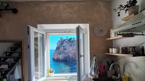 Una cocina con un ventanal grande, un fregadero y un reloj en la pared.