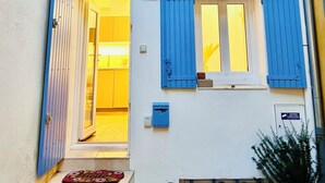 A building with a blue door and shutters, a small entrance with steps, and a potted plant on the right. - Charming house in the center of Aix, quiet, absolute, bright. (Aix-en-Provence)