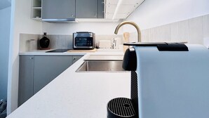 A modern kitchen with a built-in microwave, toaster, and a coffee machine. - Charming house in the center of Aix, quiet, absolute, bright. (Aix-en-Provence)