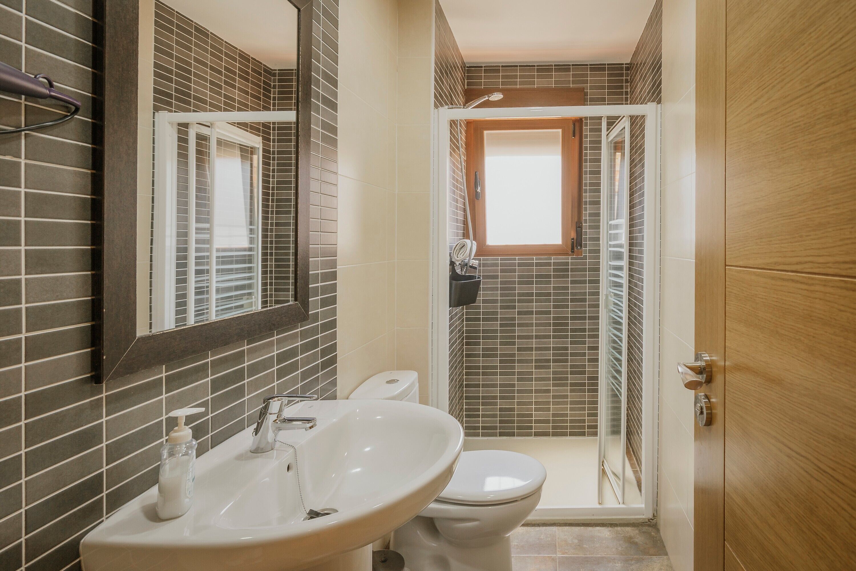 Een badkamer met wastafel, toilet en douche.
