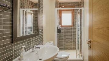 Een badkamer met wastafel, toilet en douche.