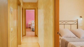 Une chambre d’hôtel avec un lit, une table de chevet et une salle de bain visible à travers une porte ouverte.