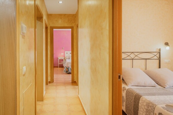 Une chambre d’hôtel avec un lit, une table de chevet et une salle de bain visible à travers une porte ouverte.
