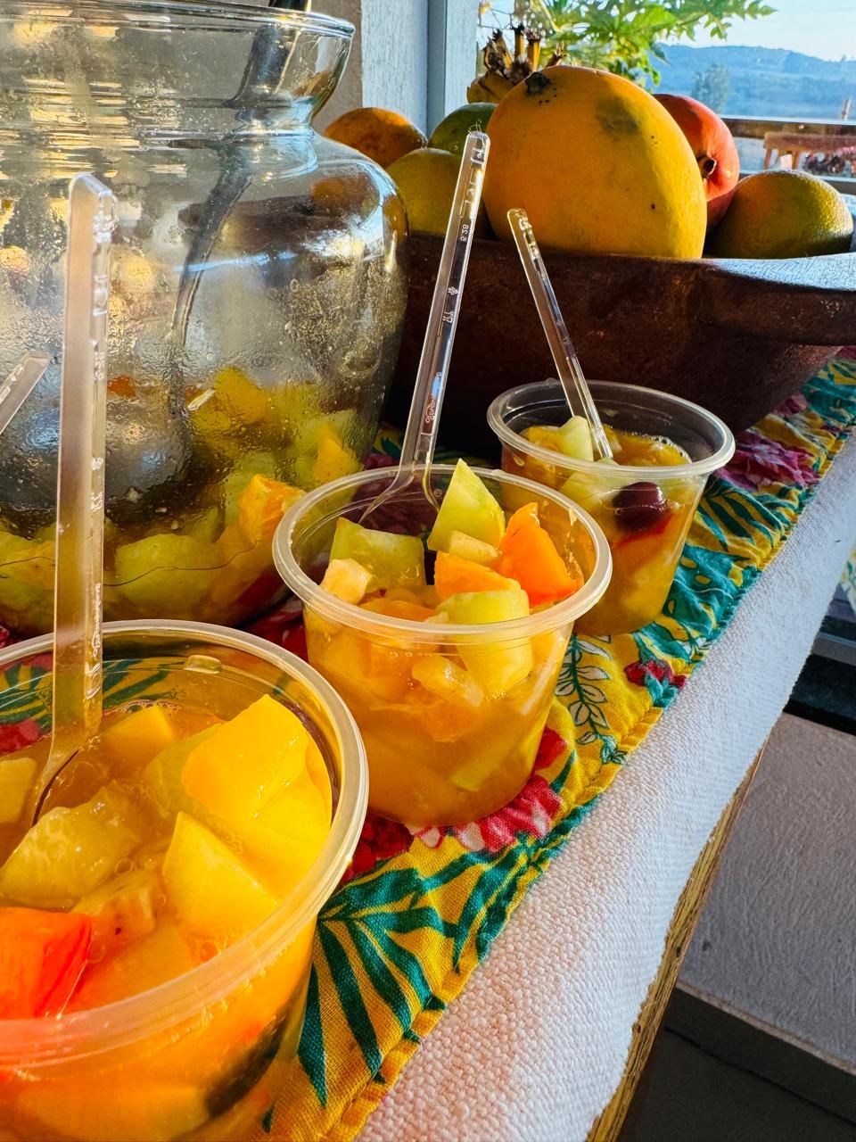 A buffet table with fruit and a large pitcher, likely containing a beverage.