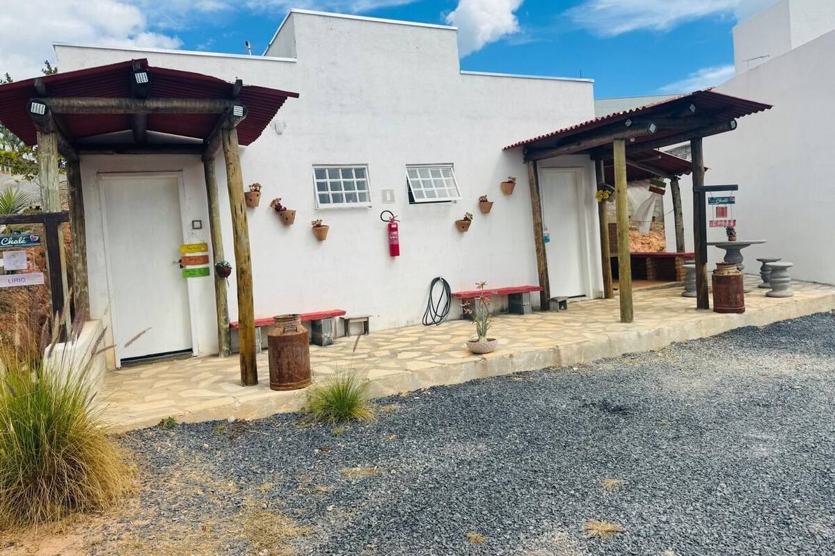 Un bâtiment doté de deux patios couverts, d’un chemin de gravier et de plantes en pot.