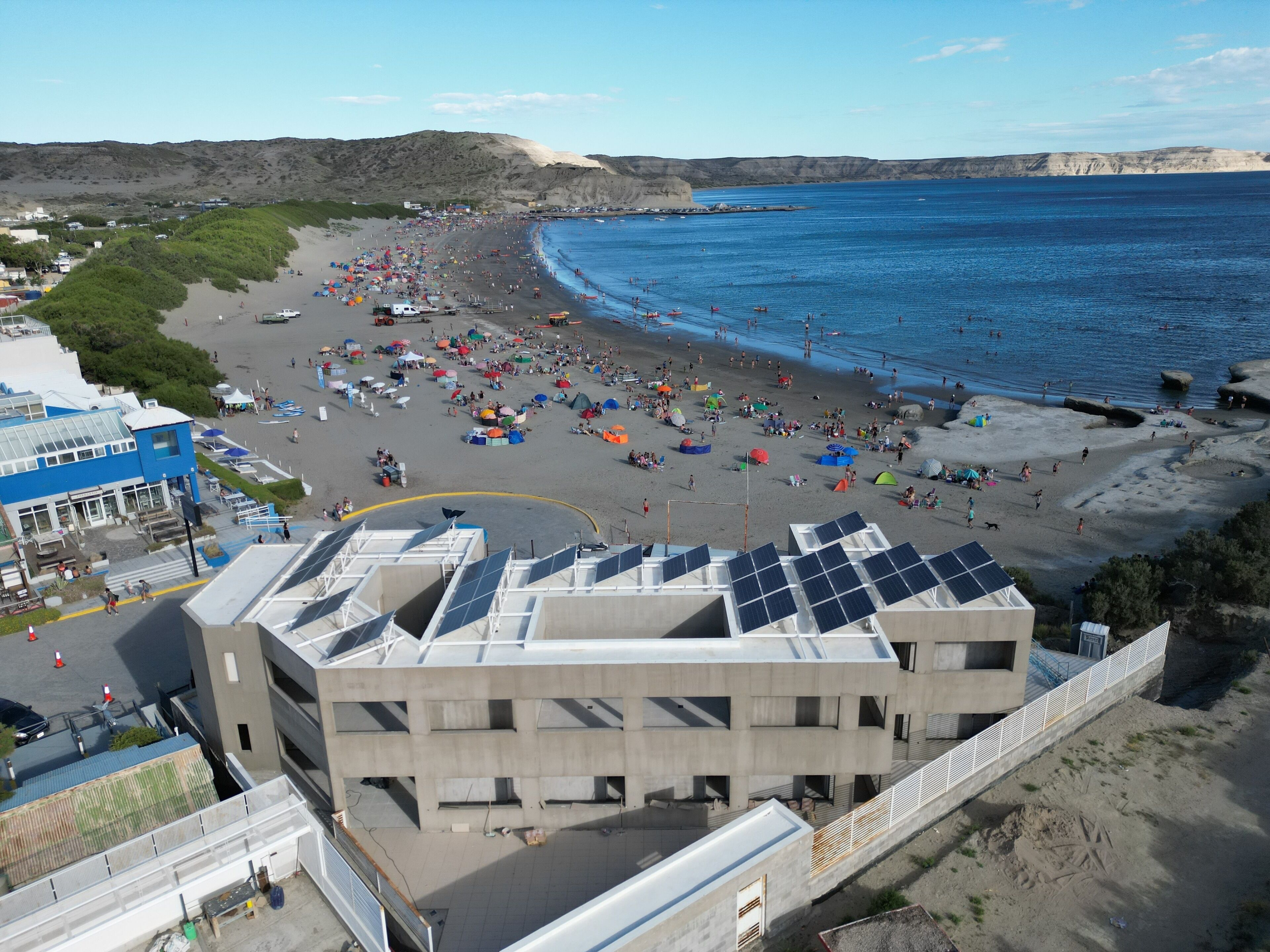 Una playa con un edificio que tiene paneles solares.